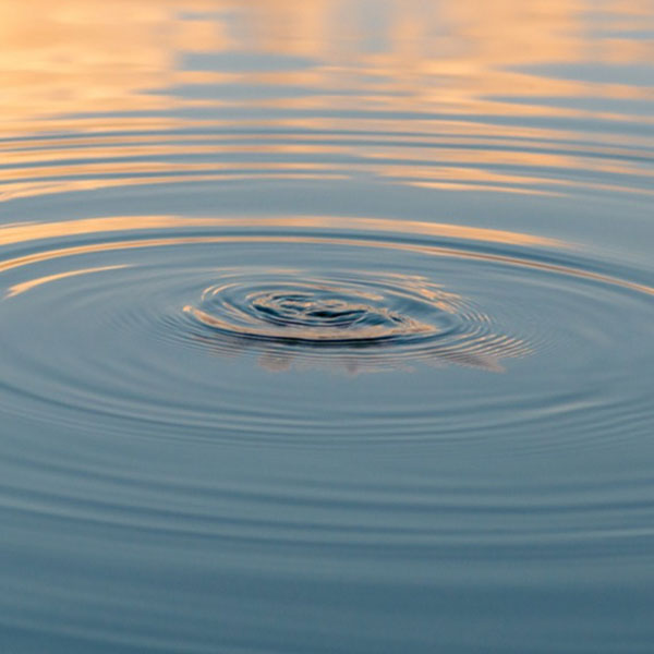 Image of rippling water with clouds reflecting in upper part of picture suggesting two different frequencies, one lighter and one darker.